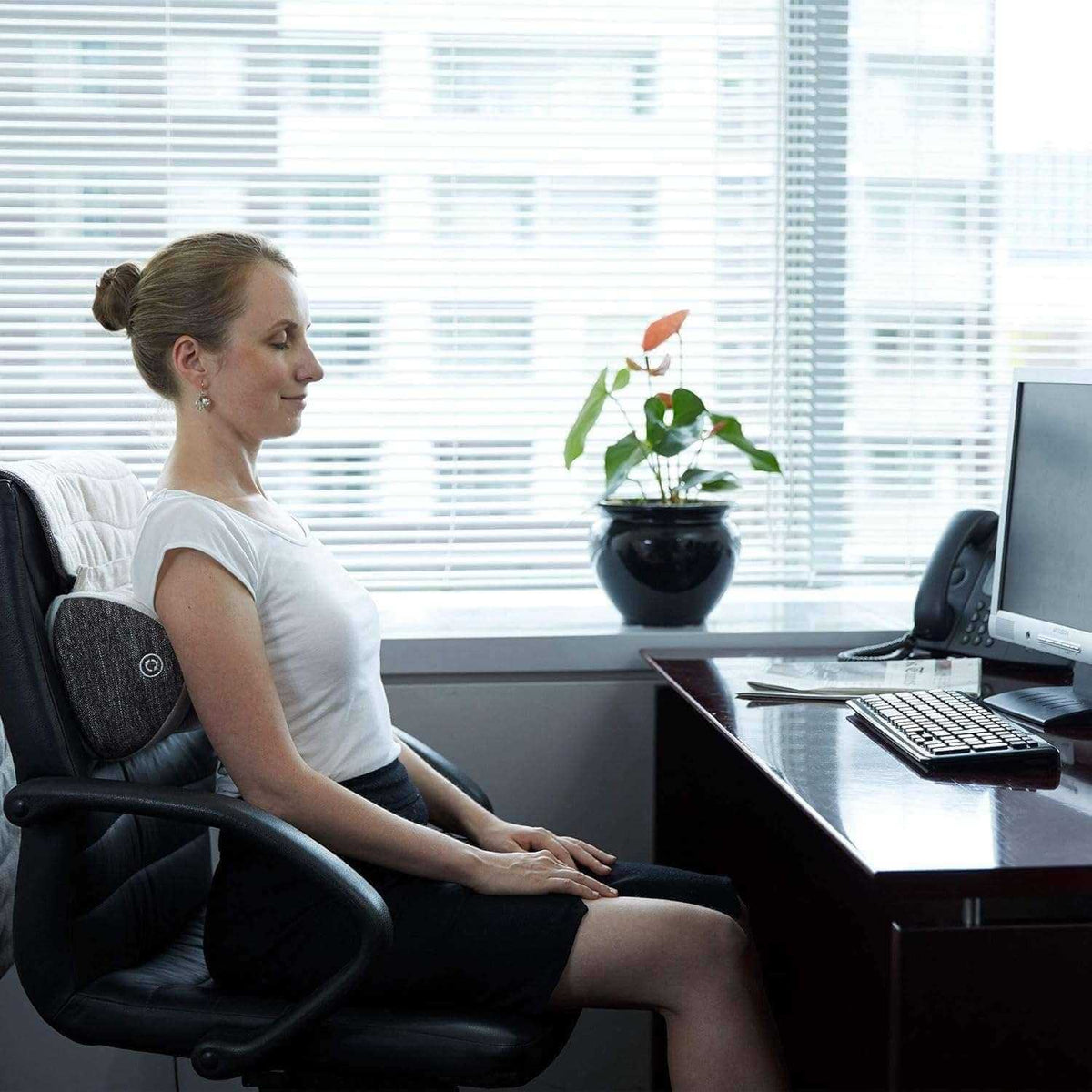 Corron Roll-Up Massage Cushion on office chair with user relaxing