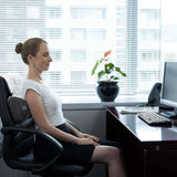 Corron Roll-Up Massage Cushion on office chair with user relaxing