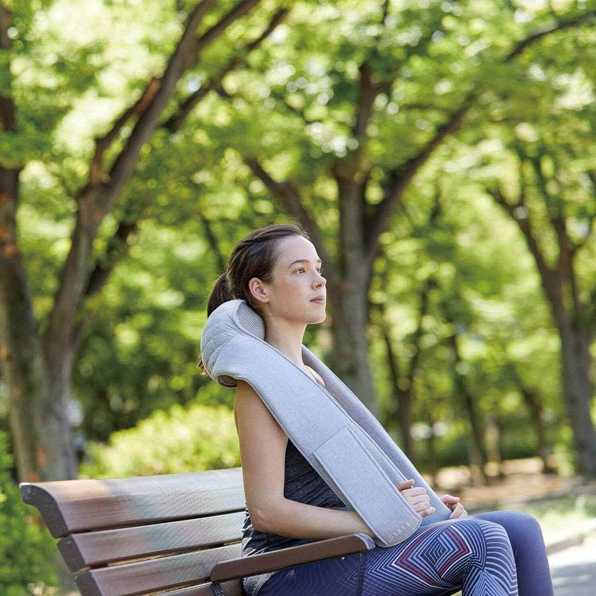 Quzy Cordless Heated Massager used outdoors on a park bench