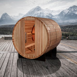 Barrel sauna on a wooden deck with mountains in the background
