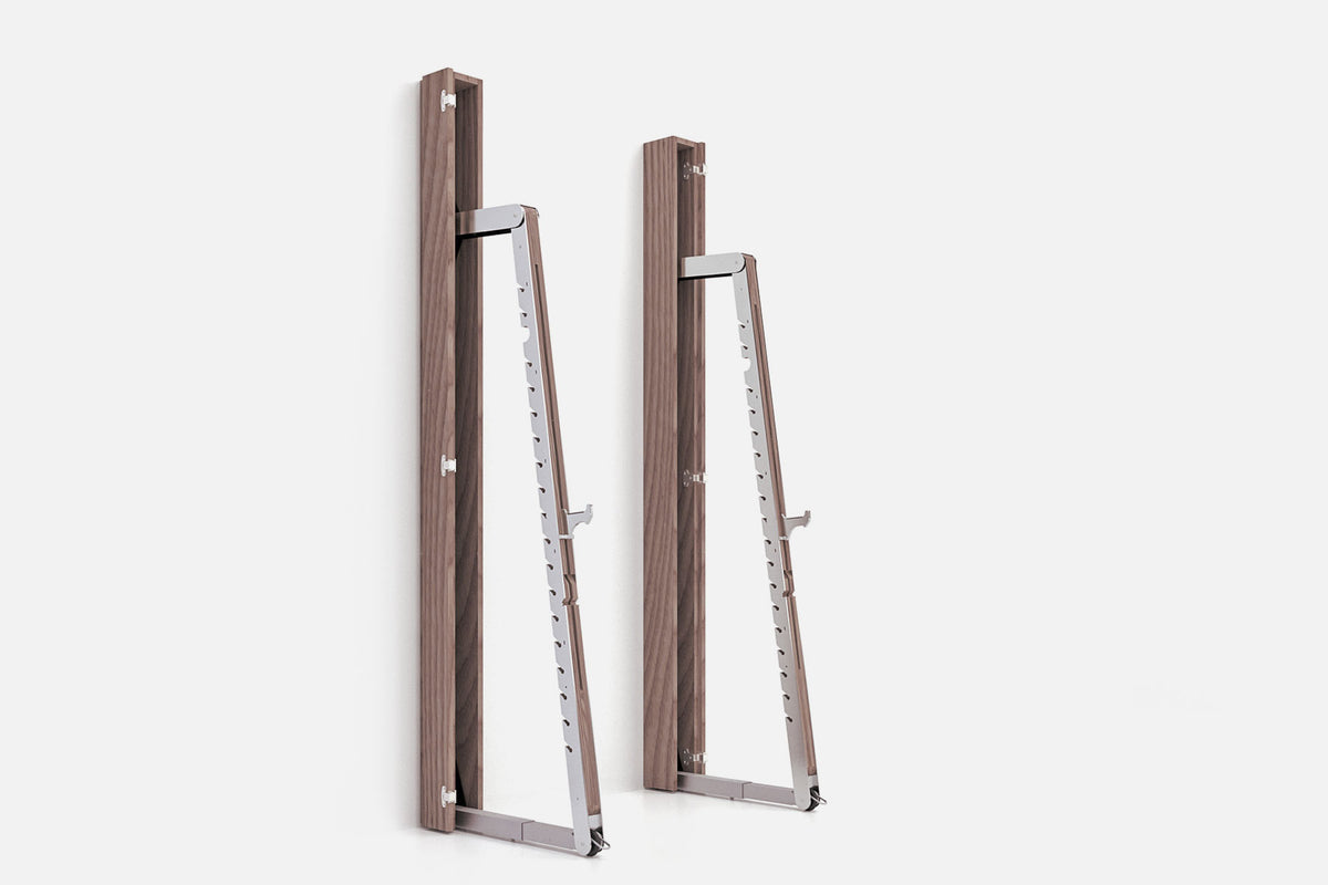 Two wall-mounted squat racks in medium-brown wood, one folded shut and one opened to a silver ladder