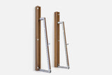 Two wall-mounted squat racks in dark brown wood, one folded shut and one opened to a silver ladder